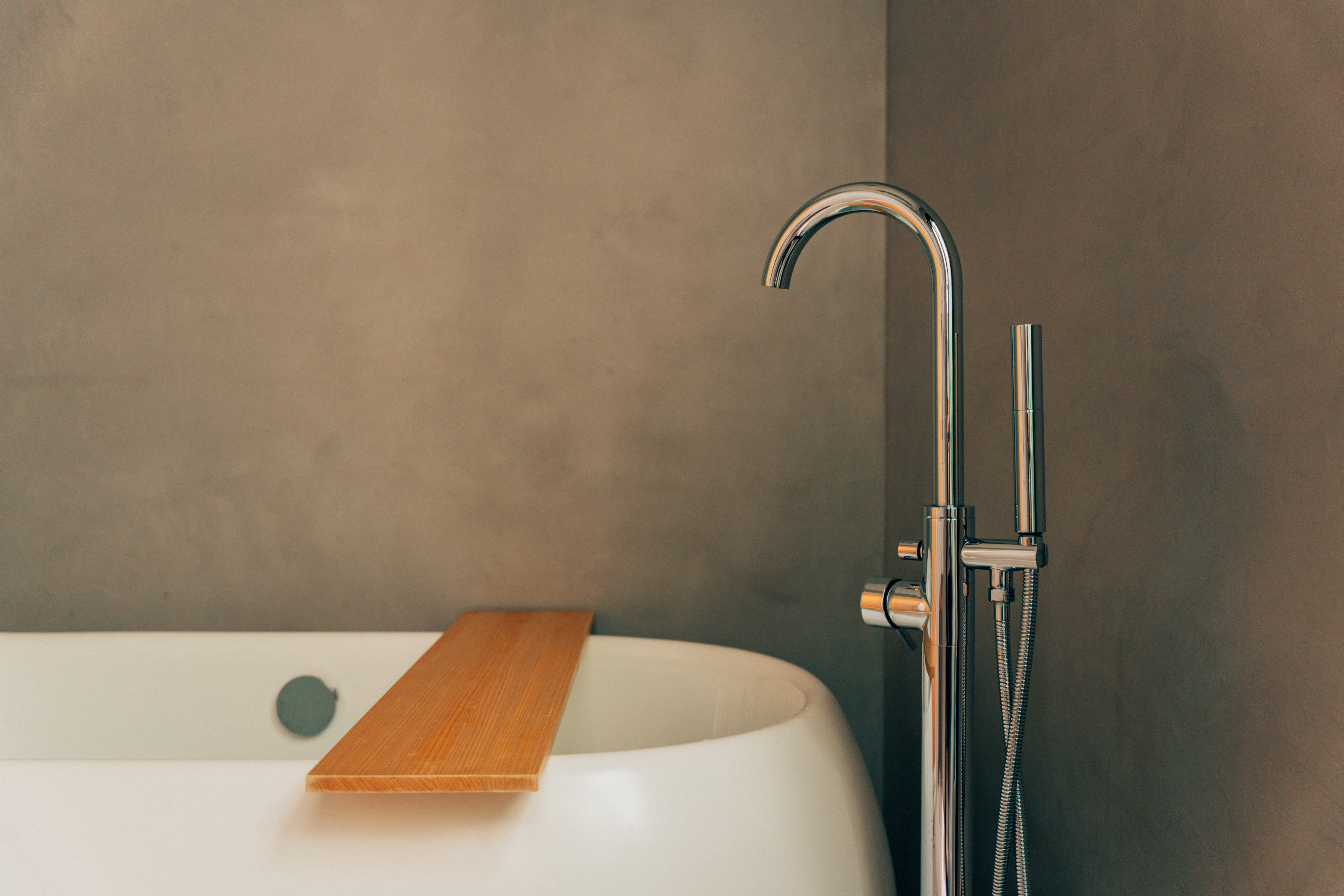 Freestanding bathtub with a wooden bath tray at One Shibuya Hill