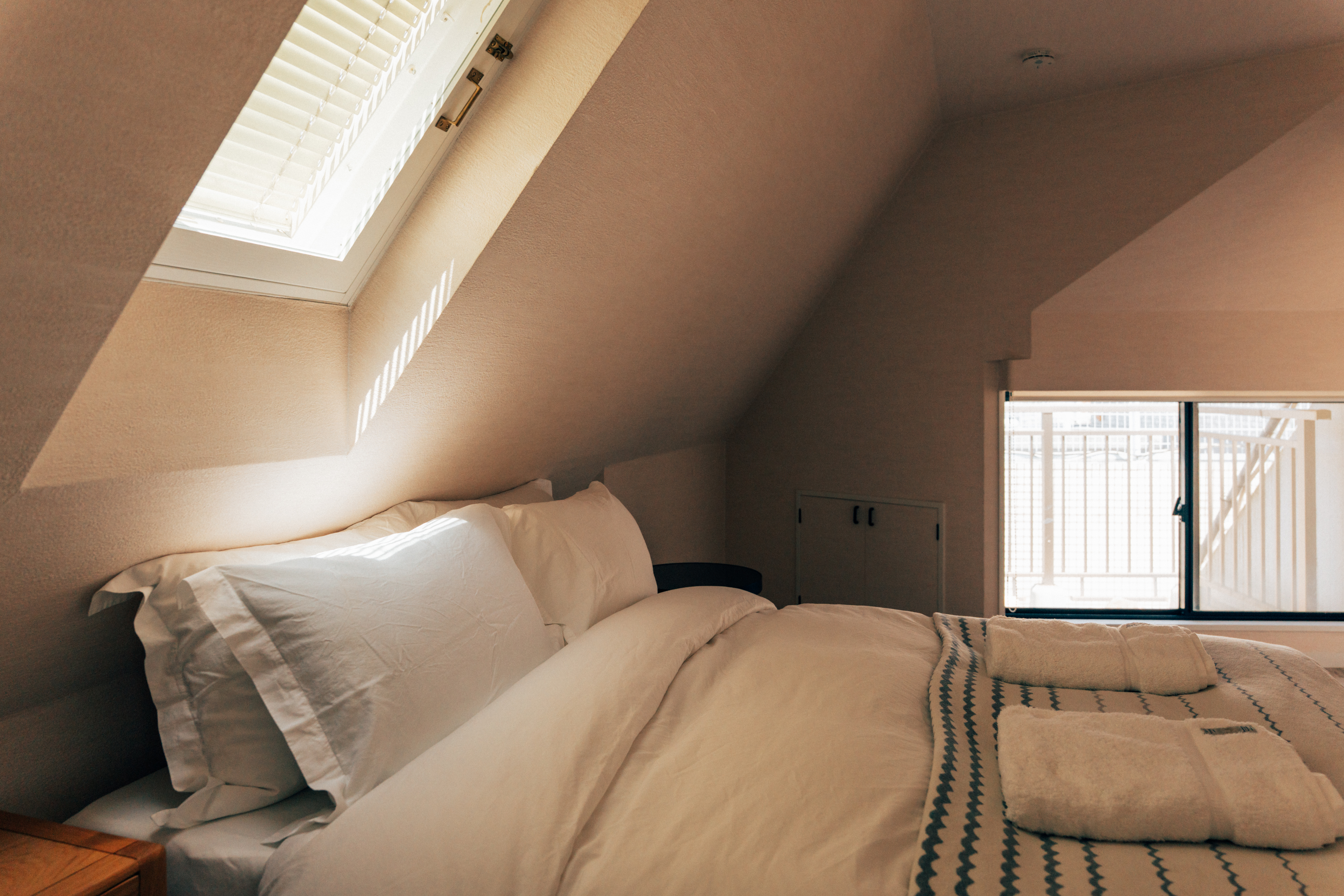 Loft bedroom illuminated by a skylight at One Shibuya Hill